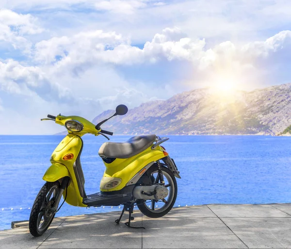 Um ciclomotor amarelo sem marca na praia em um dia de verão . — Fotografia de Stock