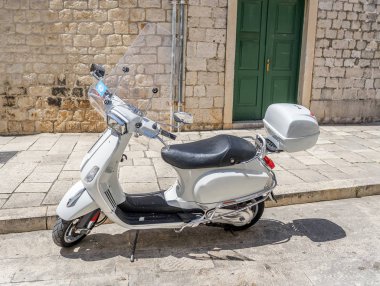 Eski şehrin sokaklarında Park beyaz scooter.