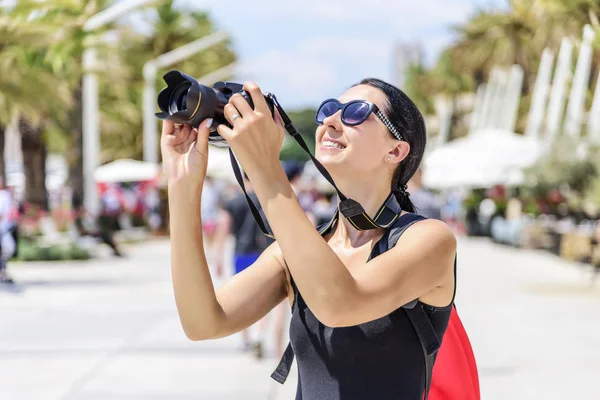 Turysta z aparatem fotografować ulice w słoneczny dzień. — Zdjęcie stockowe