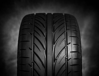 Karanlık bir arka plan üzerinde araba lastikleri.