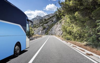Ülkenin yüksek hızlı yolu bir dağ manzarası arka planı boyunca Turist otobüsü atılıyor.