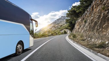 Ülkenin yüksek hızlı yolu bir dağ manzarası arka planı boyunca Turist otobüsü atılıyor.