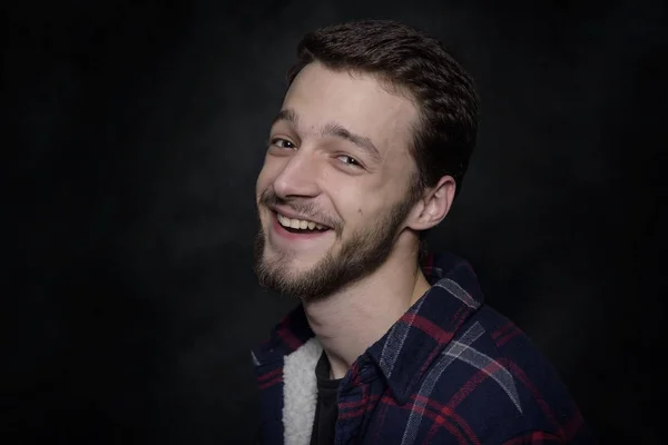 Portrait of a young man with a beard on a dark background. — Stock Photo, Image