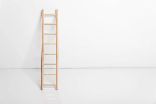 Escalera de madera apoyada contra la pared. — Foto de Stock