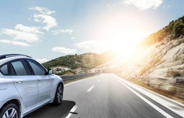 Güneş yüksek hızlı bir yolu boyunca acele bir beyaz araba.