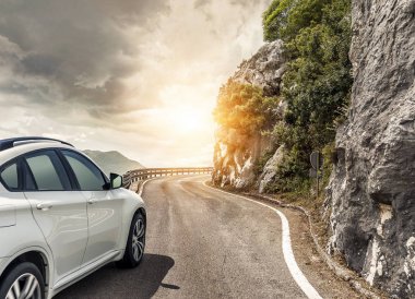 Güneş yüksek hızlı bir yolu boyunca acele bir beyaz araba.