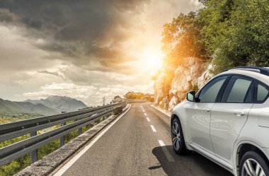 Güneş yüksek hızlı bir yolu boyunca acele bir beyaz araba.