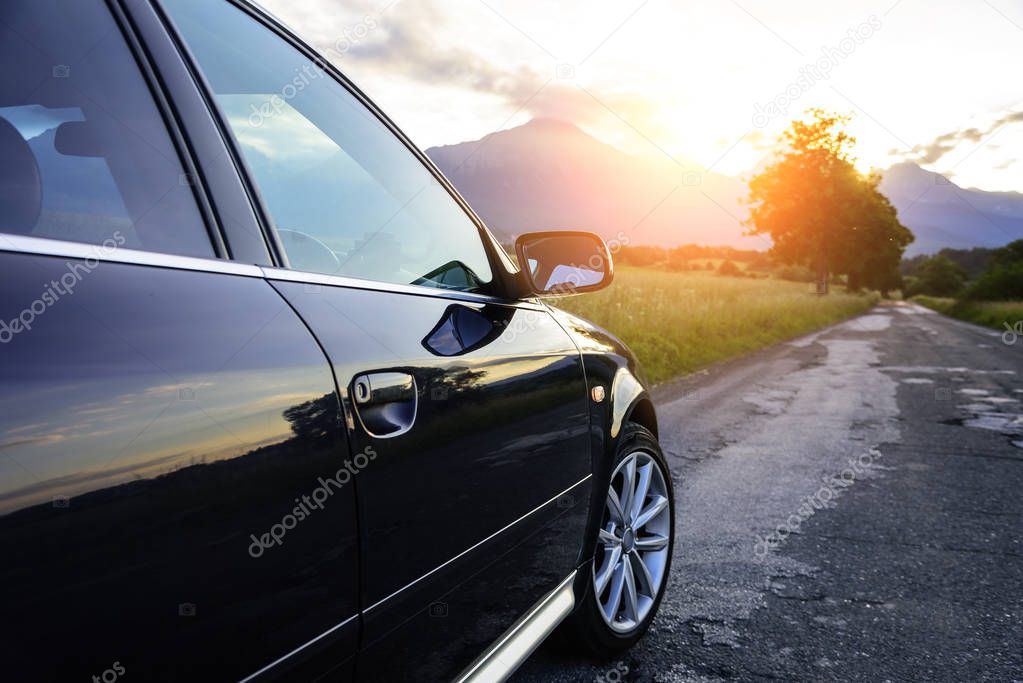 Car on a country road in the rays of the sun.