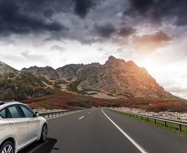Güneş yüksek hızlı bir yolu boyunca acele bir beyaz araba.