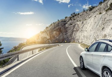 Güneş yüksek hızlı bir yolu boyunca acele bir beyaz araba.