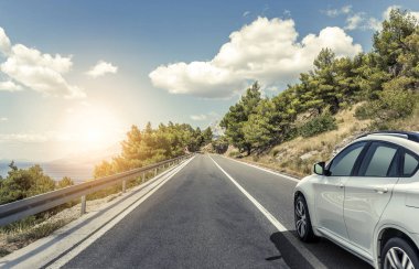 Güneş yüksek hızlı bir yolu boyunca acele bir beyaz araba.