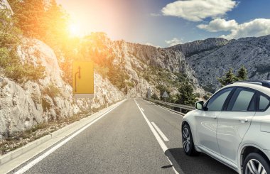 Güneş yüksek hızlı bir yolu boyunca acele bir beyaz araba.