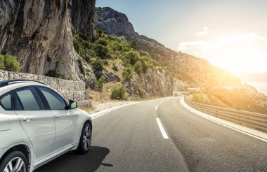 Güneş yüksek hızlı bir yolu boyunca acele bir beyaz araba.