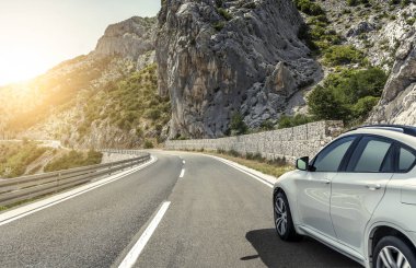Güneş yüksek hızlı bir yolu boyunca acele bir beyaz araba.