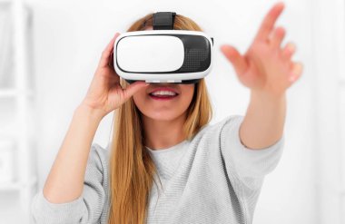 Güzel genç kadın sanal gerçeklik bardaklarda Oyun oynama.