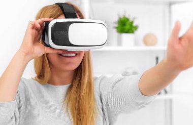 Güzel genç kadın sanal gerçeklik bardaklarda Oyun oynama.