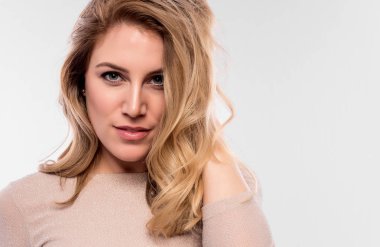 Çekici tatlı bir sarışın. Bir beyaza yakın çekim portre. Bir ten rengi elbise güzel genç kadın.