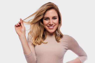 Çekici tatlı bir sarışın. Bir beyaza yakın çekim portre. Bir ten rengi elbise güzel genç kadın.