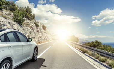 Güneş yüksek hızlı bir yolu boyunca acele bir beyaz araba.