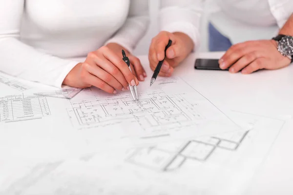 Employees work on blueprints or engineering plans in the office. Engineering. Stock Photo