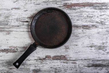 Ahşap masa üzerinde siyah antika kızartma tavası.