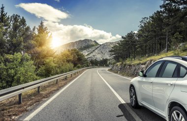 Güneş yüksek hızlı bir yolu boyunca acele bir beyaz araba.