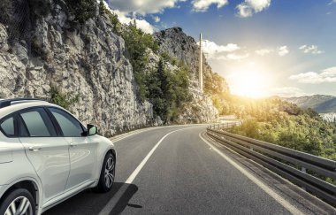 Güneş yüksek hızlı bir yolu boyunca acele bir beyaz araba.