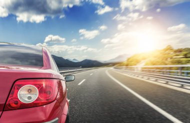 Kırmızı araba hızlı bir otoyolda koşuyor..