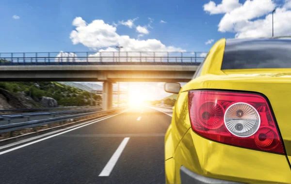 Gelbes Auto rast auf Hochgeschwindigkeitsautobahn. — Stockfoto