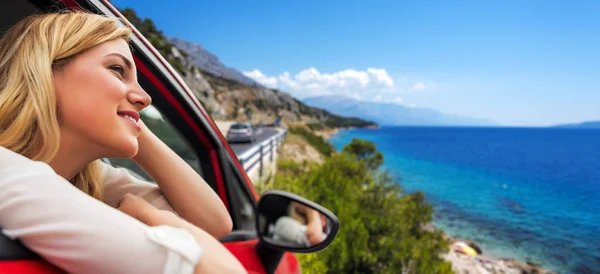 Utazás, vagy nyaralás. Gyönyörű szőke lány autó az úton, hogy a tenger. — Stock Fotó