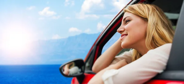 Travel or vacation. Beautiful blond girl in car on the road to the sea. Royalty Free Stock Images