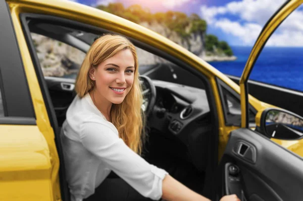 Jonge vrouw besturen van een auto op de weg naar de zee. — Stockfoto