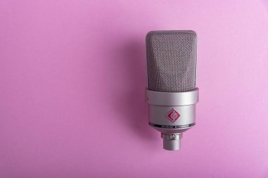 Büyük diyafram yoğunlaştırıcı stüdyo mikrofonu Neumann tm 103 pembe arka planda..