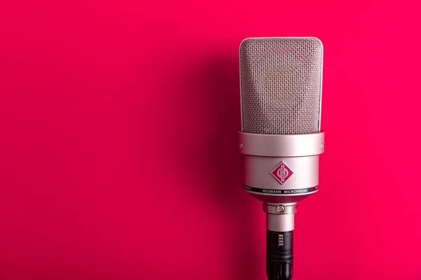 Large diaphragm condenser studio microphone Neumann tlm 103 on a red background. — Stock Photo, Image