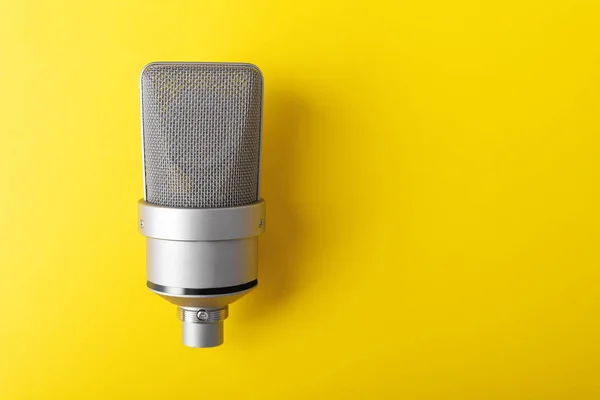 Large diaphragm condenser studio microphone. On yellow background. — Stock Photo, Image