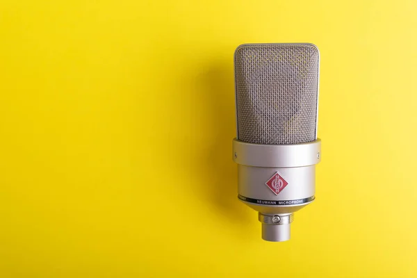 Large diaphragm condenser studio microphone Neumann tlm 103 on yellow background. — Stock Photo, Image