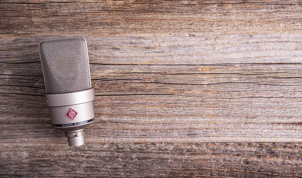 Large diaphragm condenser studio microphone Neumann tlm 103 on a wooden background. — Stock Photo, Image