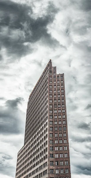 Um edifício alto contra um céu nublado . — Fotografia de Stock