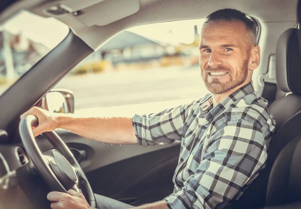 Attraktiver Mann am Steuer eines weißen Autos. — Stockfoto