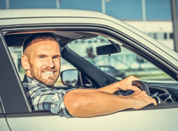 Uomo attraente alla guida di una macchina bianca . — Foto Stock