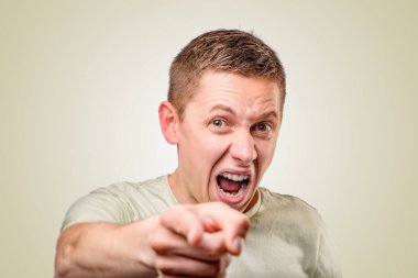 Genç adam bağırıyor ve işaret ediyor.