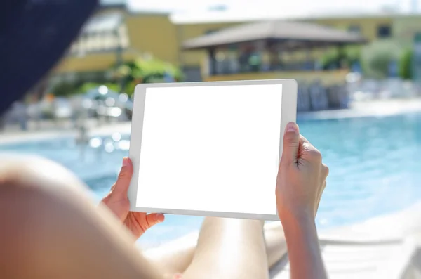 Young woman with a tablet by the pool — Stockfoto