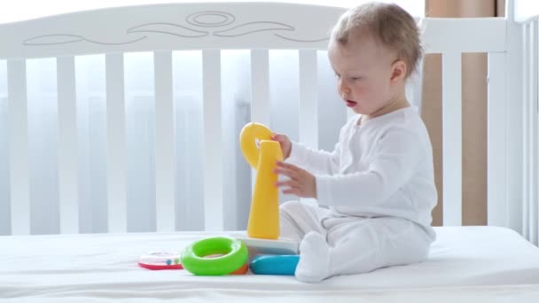 Menina bebê brincando com brinquedos na cama . — Vídeo de Stock