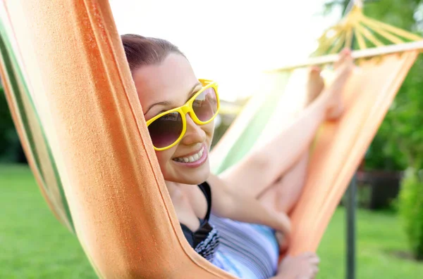 Yong woman enjoy in orange hammock — Stock Photo, Image