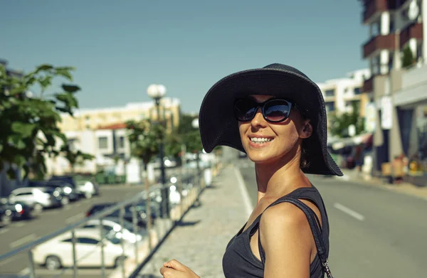 Fashionabla flicka i en hatt poserar på en stadsgata. — Stockfoto