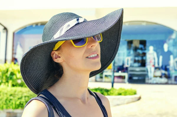 Fashionabla flicka i en hatt poserar på en stadsgata. — Stockfoto