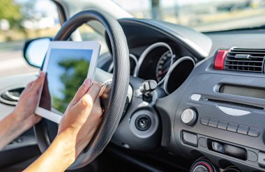 Tablet bilgisayarlı kadın arabada oturuyor..