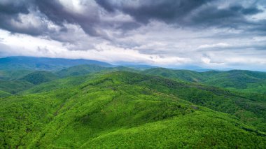 Dağlarda bahar manzarası ve bulutlu koyu mavi gökyüzü..