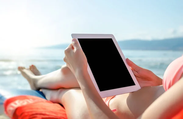Férias. Mulher com um tablet pc ou smartphone na praia . — Fotografia de Stock