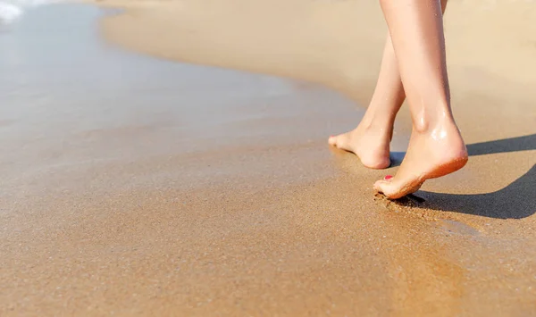 Pernas femininas caminham na areia do mar . — Fotografia de Stock